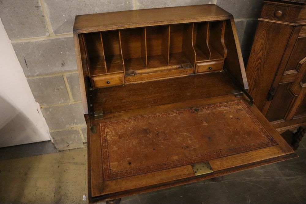 A 1920s panelled oak bureau, width 74cm, depth 46cm, height 103cm, together with a similar standing corner cabinet
